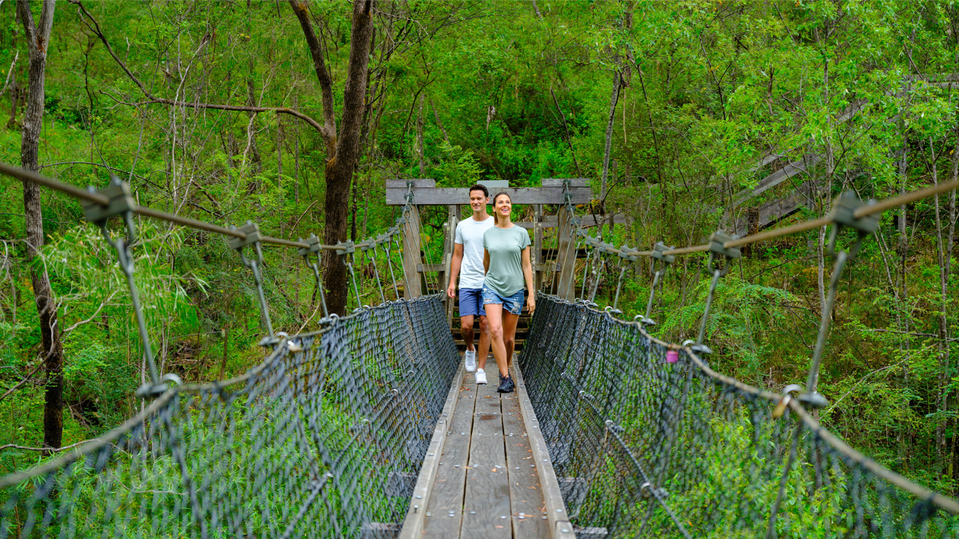 Couple crossing bridge in south west forrest